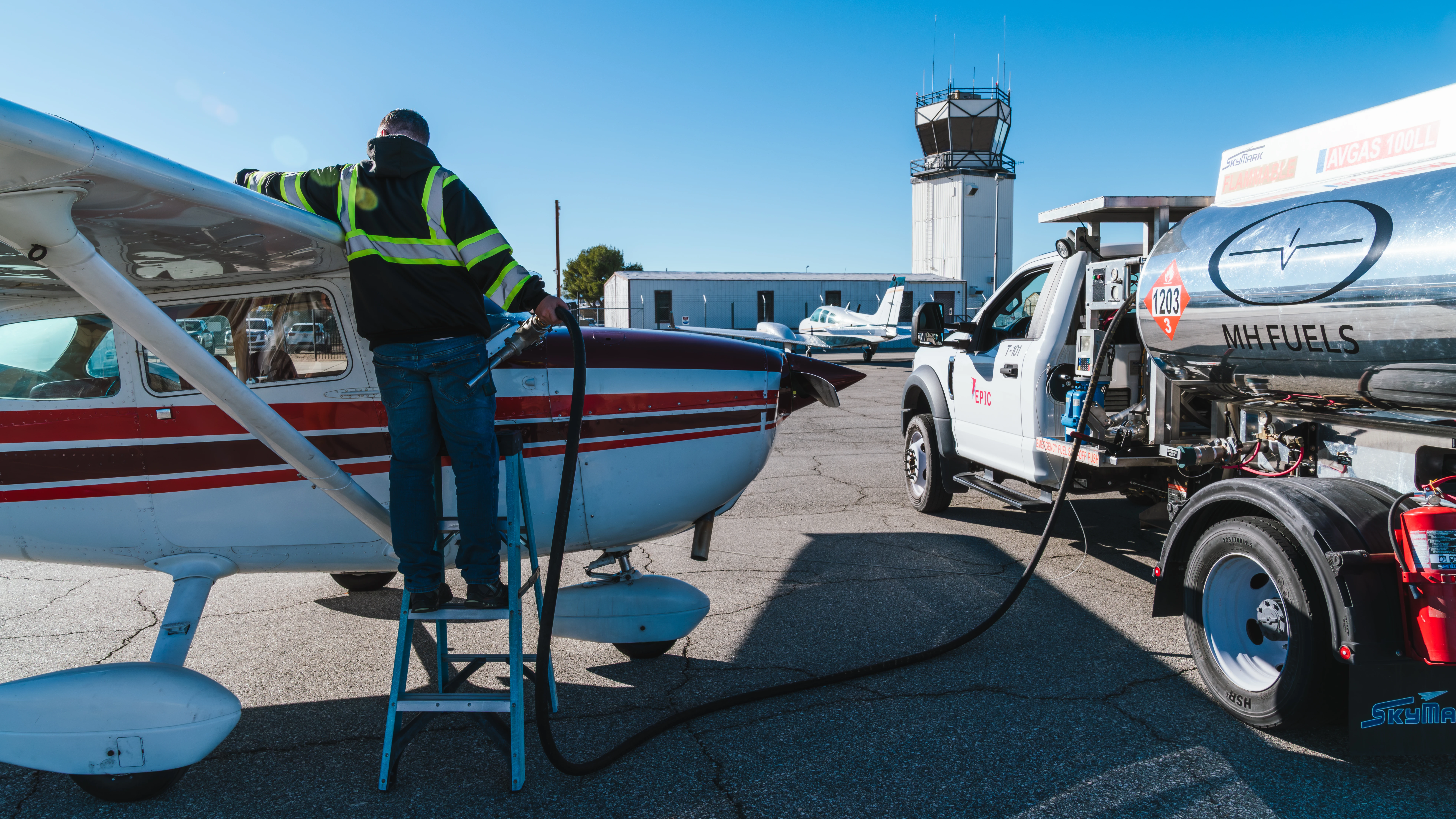 Technician performing hands-on aircraft maintenance on a ladder at MH Aviation at Lancaster, California