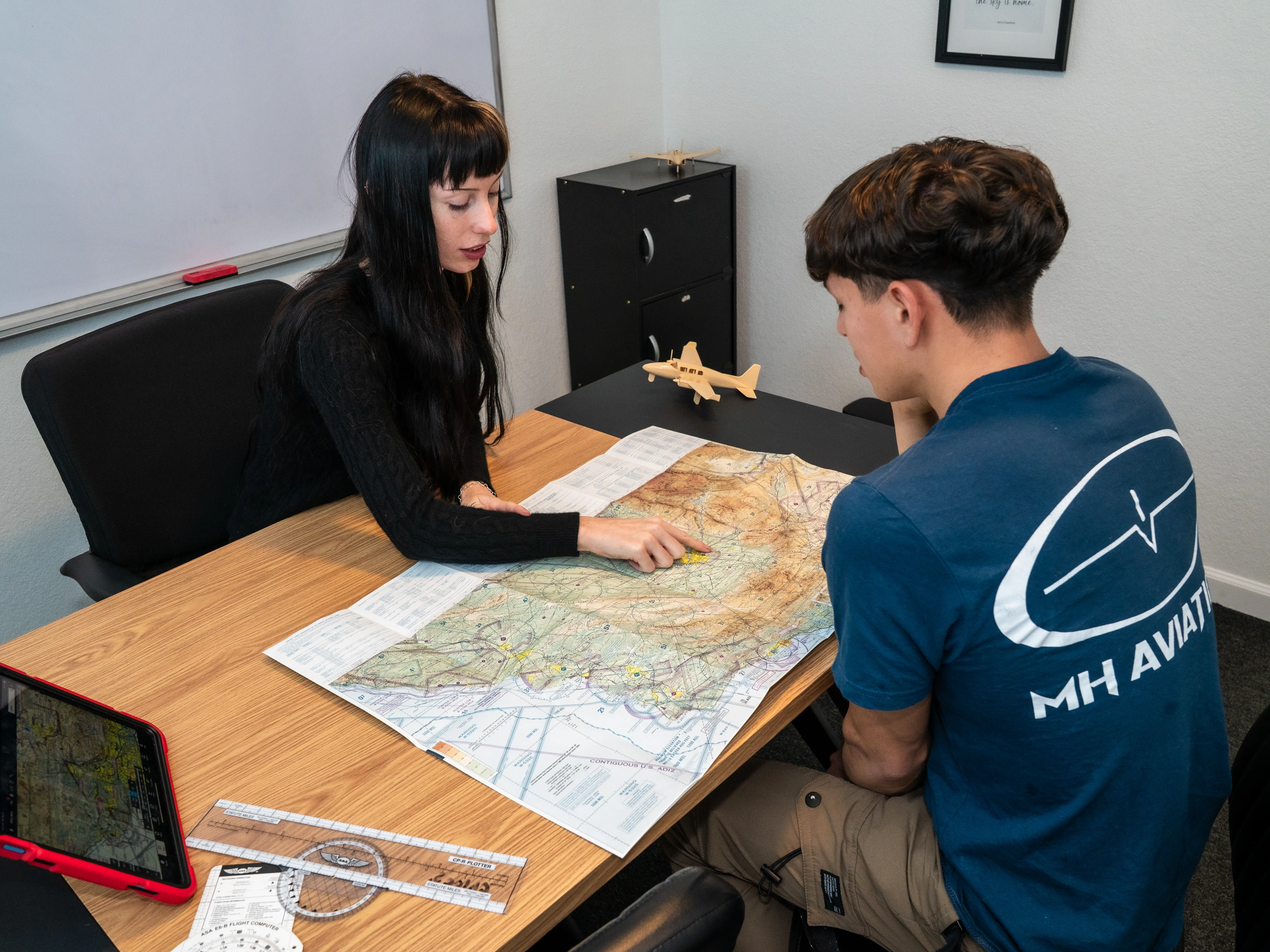 MH Aviation instructor on table showing map